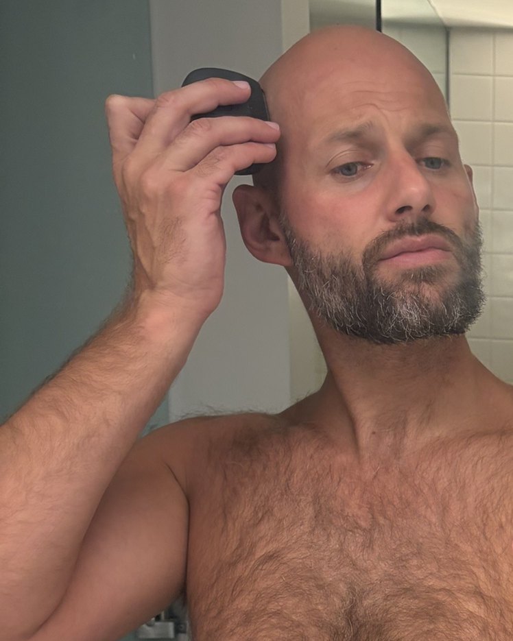 Mark Cronje shaving his head with the Panasonic ES-PV3B in a hotel bathroom mirror